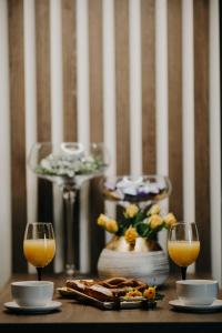 a table with two glasses of orange juice and a plate of food at Apartman Stari Toranj in Vukovar
