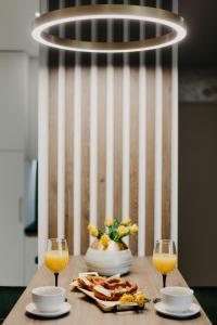 a table with a plate of food and two glasses of orange juice at Apartman Stari Toranj in Vukovar