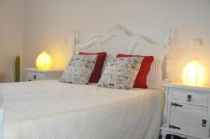 um quarto com uma cama branca e 2 candeeiros em O cantar dos passarinhos em Fátima