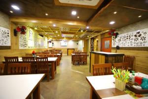 a restaurant with wooden tables and chairs and a dining room at Hotel Royal Phoenix in Agra