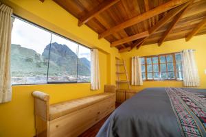 a yellow bedroom with a bed and a large window at San Isidro's House in Ollantaytambo