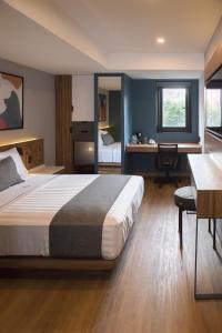 a bedroom with a bed and a desk in a room at Hotel Flamencos in Mexico City
