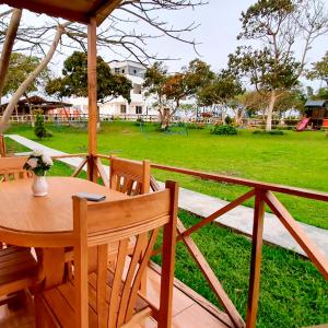 a wooden table and chairs with a park in the background at Apart Hotel El Paraíso de Barranca in Barranca