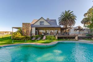 una casa con piscina frente a una casa en Kana guest farm - 35 rooms for 70 guests en Stellenbosch
