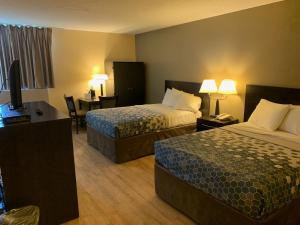 a hotel room with two beds and a desk at Days Inn by Wyndham Harrisonburg in Harrisonburg