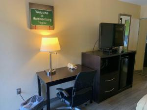 a room with a desk with a tv and a chair at Days Inn by Wyndham Harrisonburg in Harrisonburg