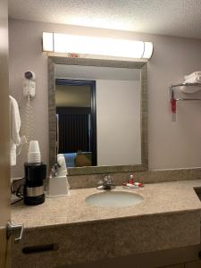 a bathroom counter with a sink and a mirror at Days Inn by Wyndham Harrisonburg in Harrisonburg