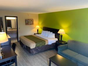 um quarto de hotel com uma cama e um sofá em Days Inn by Wyndham Harrisonburg em Harrisonburg