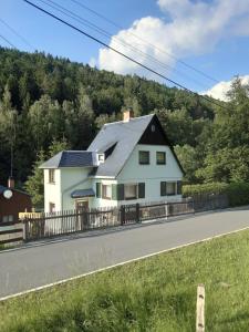 een wit huis aan de kant van een weg bij Ferienhaus Rosemarie Erlbach Vogtland in Erlbach