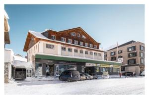 a building with cars parked in a parking lot at Appartements Insieme in Obertauern