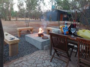 a fire pit with benches and a table and a table and chairs at Vulture's View 1 in Hartbeespoort