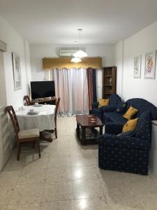 ein Wohnzimmer mit einem blauen Sofa und einem Tisch in der Unterkunft Apartment,NEAR THE BEACH Pinikoudes in Larnaka