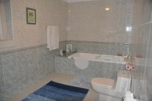 uma casa de banho com uma banheira, um WC e um lavatório. em O cantar dos passarinhos em Fátima