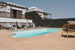 a swimming pool in front of a house at CASA MOCI in Playa Blanca