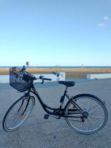 Una bicicleta con una cesta estacionada en la playa en Aires de Mar, en Playa Honda
