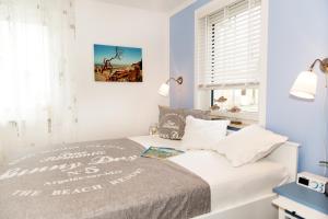 a bedroom with a bed with white walls and a window at Whg 11 - Sonnencamp in Zingst