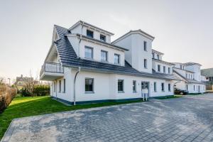 a white house with a black roof at Whg 11 - Sonnencamp in Zingst