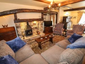 a living room with a couch and a fireplace at Mill Farm - The Farmhouse in Derby