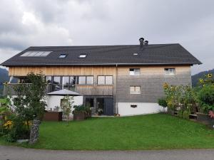 uma casa com painéis solares no telhado em Ferienwohnung Gmeiner em Hittisau