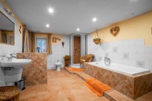 a large bathroom with a tub and a sink at Vlčihorská chaloupka in Krásná Lípa