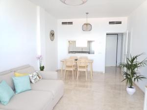 uma sala de estar branca com um sofá branco e uma mesa em Ocean View Playa Negra Apartment em Puerto de Santiago