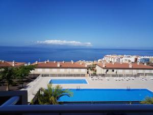 uitzicht op een zwembad en de oceaan bij Ocean View Playa Negra Apartment in Puerto de Santiago