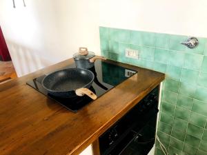 a pan sitting on top of a stove in a kitchen at iRIVAS Lodge in Pellizzano