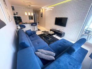 シュチェチンにあるLivin Aparthotel Centrumのレンガの壁のリビングルーム(青いソファ付)