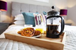 a tray with a coffee maker and pastries on a bed at Urban Living's - The Wesley Beautiful City Centre Apartment with Balcony in Oxford
