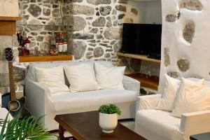 a living room with a white couch and a tv at Lava House in Mandrakion