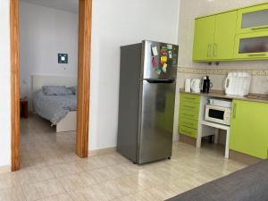 a kitchen with a stainless steel refrigerator and green cabinets at Aires de Mar in Playa Honda