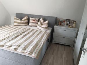 a bedroom with a bed with pillows and a night stand at Ferienwohnung Söhreblick in Wattenbach