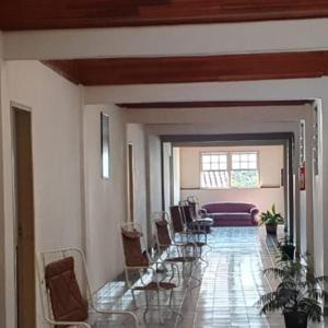 um corredor com cadeiras, uma mesa e um sofá em Apart Hotel Flomon em Ouro Preto