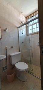 uma casa de banho com um WC e uma cabina de duche em vidro. em Apart Hotel Flomon em Ouro Preto