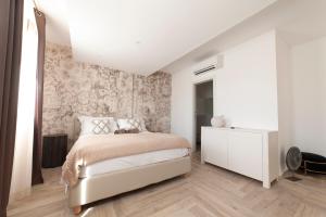 a bedroom with a bed and a dresser at Suimi's Hotel in Villasimius