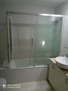 een glazen douche in een badkamer met een wastafel bij Vista Espléndida Jardines de Altea Hills in Altea