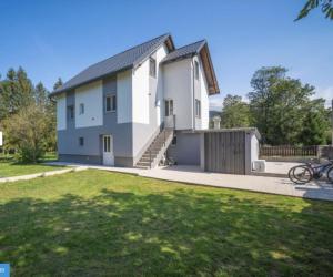 a white house with a fence and a yard at Villa Green Oasis in Fužine
