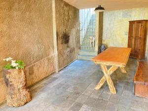 a wooden table in a room with a dog in the background at º Real Central Suite º in Ouro Preto
