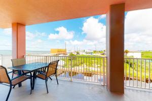 a balcony with a table and chairs and a view of the ocean at Paradise Shores 200 in Mexico Beach