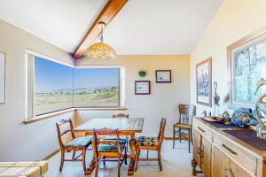 a dining room with a table and chairs and a window at Pinnacle Heights in Bodega Bay