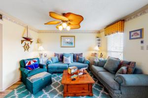 a living room with two blue couches and a table at Beach Front #203 in Gulf Shores