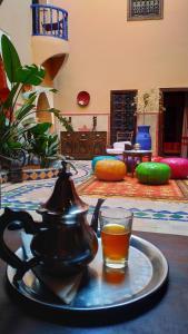 Riad Basma Marrakech في مراكش: غلاية شاي وكأس على طاولة