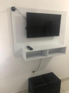 TV de pantalla plana colgada en una pared blanca en Apartamento em Floripa -Muito próximo ao Aeroporto en Florianópolis