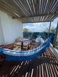 a hammock on a deck with a view of the ocean at Kilombo Villas & Spa in Pipa