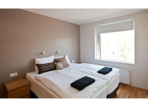 a bedroom with a bed with two towels on it at Torg Guest House in Akureyri