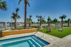 a swimming pool with palm trees in a park at Calypso Resort Tower 3 by Panhandle Getaways in Panama City Beach +8 photos