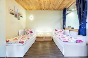 2 białe łóżka w pokoju z oknem w obiekcie Ferienhaus Sonne Mond und Sterne b w mieście Steffenshagen