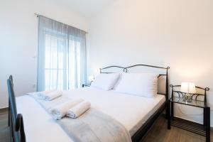 - une chambre avec un lit doté d'oreillers blancs et d'une fenêtre dans l'établissement Vila Apartments Marina, à Blato