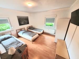 ein Wohnzimmer mit 2 Betten und einem Sofa in der Unterkunft Lieblingsmensch Oberhausen mit Terrasse in Oberhausen
