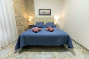 1 dormitorio con 1 cama azul y 2 toallas en Casa Estrella y Casa Carmen, en Denia